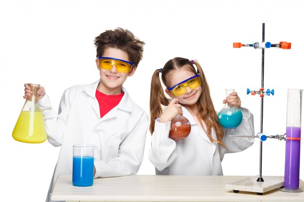 Две милые дети на уроке химии делают эксперименты