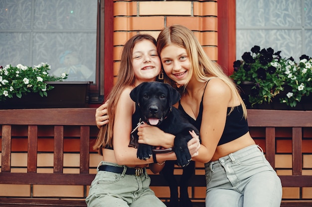 Due ragazze carine in un parco estivo con un cane