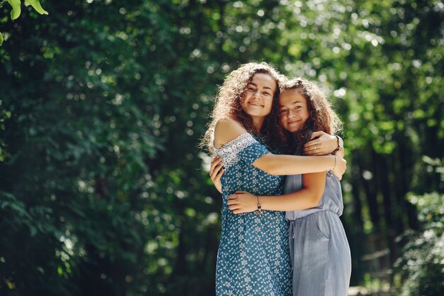 Two cute sisters in a summer park