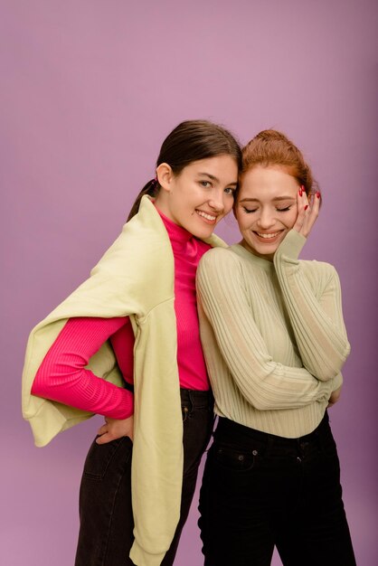 Two cute young caucasian women in casual clothes with smile on their face posing on purple background People sincere emotions lifestyle concept