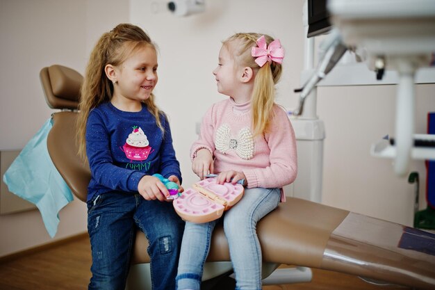 Two cutie little baby girls at dentist chair Children dental