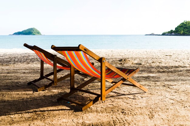 모래 해변에 2 개의 deckchairs