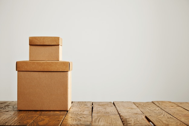 Free photo two different sized beige corrugated cardboard unlabeled boxes presented on top of each other isolated on white