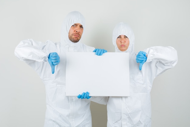 防護服を着た2人の医師、空白のキャンバスを保持している手袋