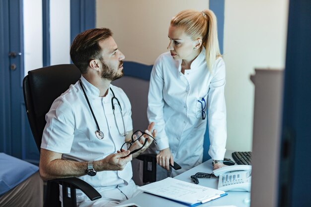 Two doctors talking about patient's medical reports while working in the hospital