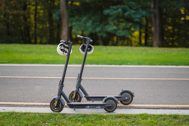 Two e-scooter parked on the sidelines road in the park