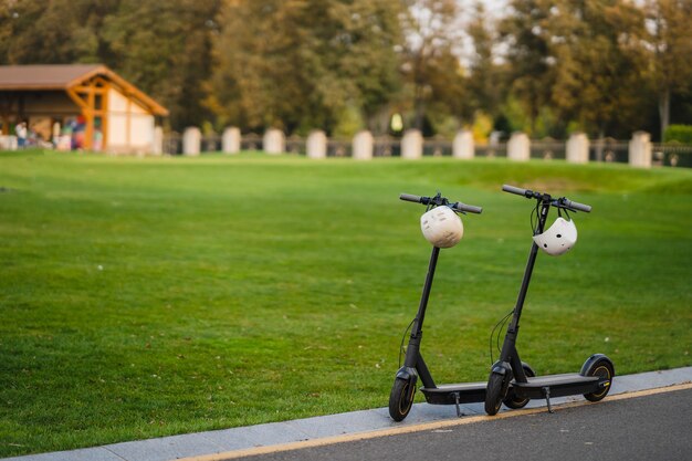 Two electric kick scooters or e-scooter parked on the sidelines road