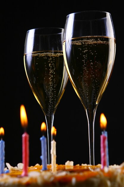 Two elegant glasses with gold champagne and cake