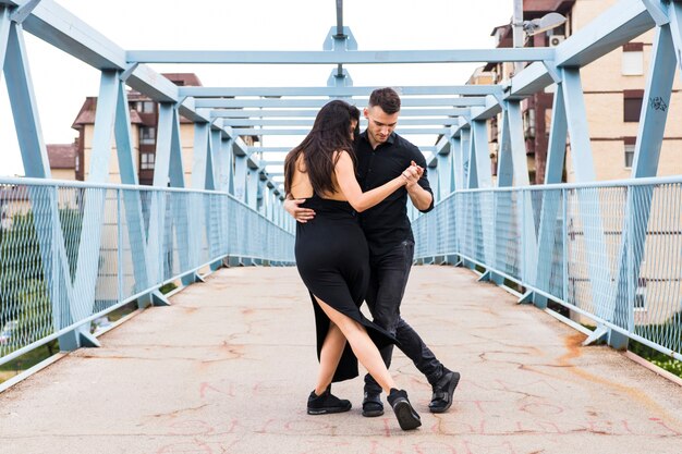 Two elegant tango dancers on bridge