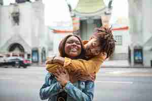 Free photo two embraced friends smiling while out in the city