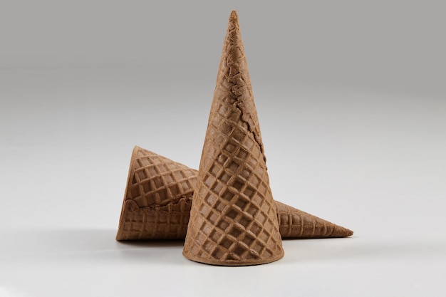 Два пустых, больших, шоколадных вафельных рожка для мороженого, изолированных на белом. Концепция еды, угощений. Макет, шаблон для рекламы и дизайна. Крупным планом