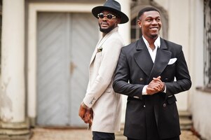 Free photo two fashion black men fashionable portrait of african american male models wear suit coat and hat
