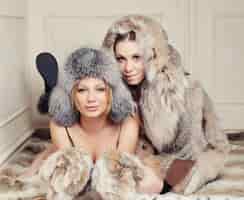 Free photo two fashionable women in fur coats and hats.