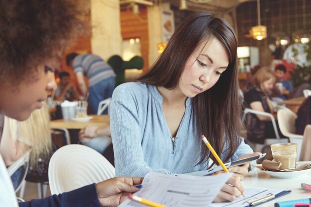 Two female coworkers working together in cafe