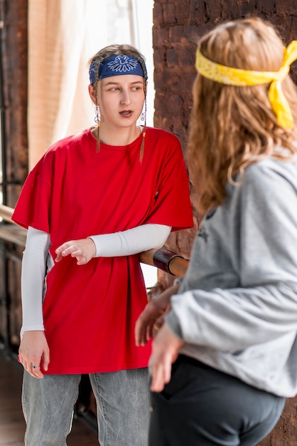 Free photo two female dancer standing in the dance studio talking to each other