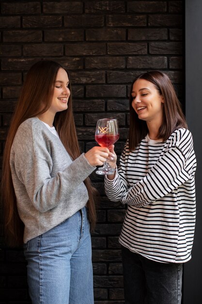 Two female friends cheering with a glass of wine