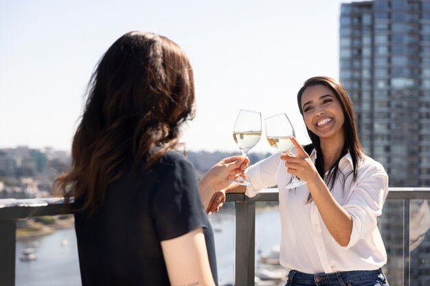 옥상 테라스에서 대화하고 와인을 즐기는 두 명의 여자 친구