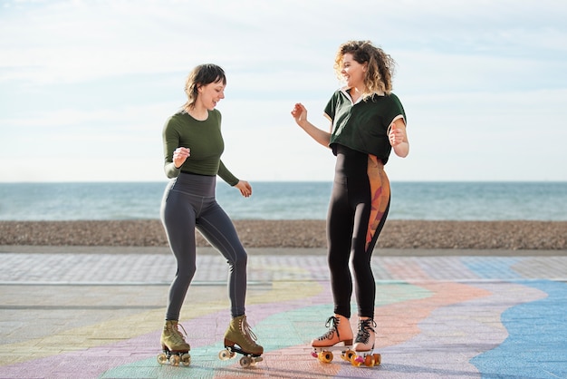 Two female friends dancing with roller skates outdoors