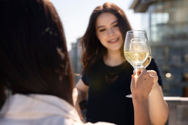 Two female friends enjoying some wine on a rooftop terrace