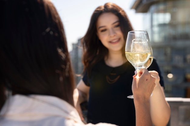 Two female friends enjoying some wine on a rooftop terrace