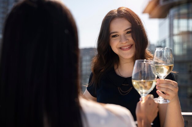 Due amiche che si godono un po' di vino su una terrazza sul tetto