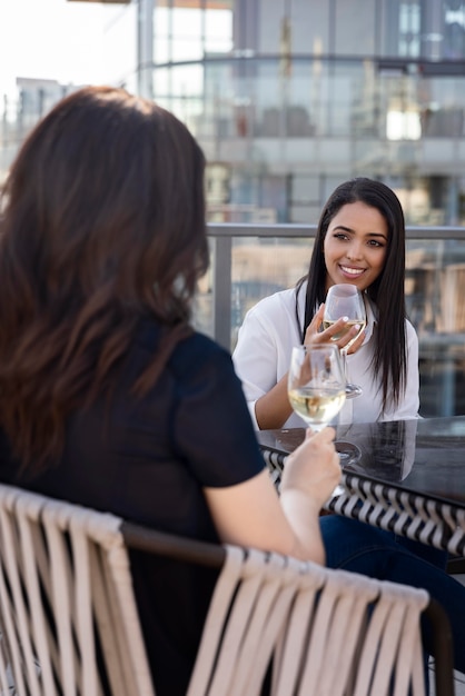 屋上テラスでワインを楽しむ2人の女性の友人