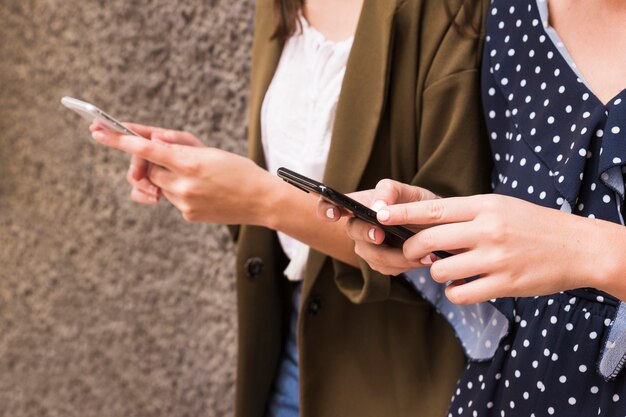 Two female friends holding mobile phone