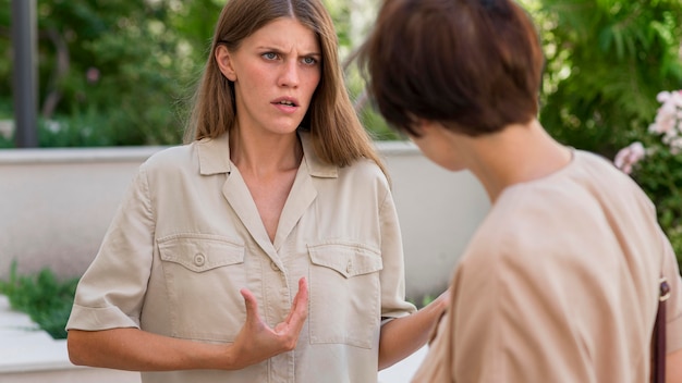 Two female friends outdoors conversing through sign language