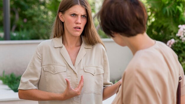 Two female friends outdoors conversing through sign language