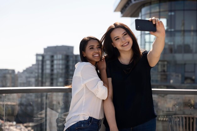 Two female friends at a rooftop terrace taking a selfie