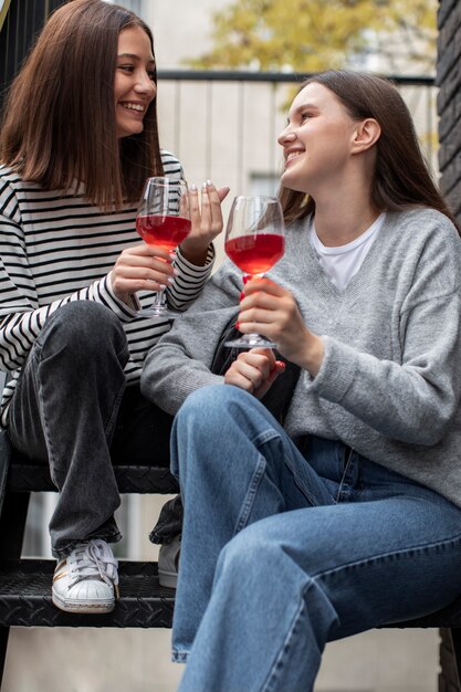 와인 한 잔과 함께 웃고 환호하는 두 여자 친구