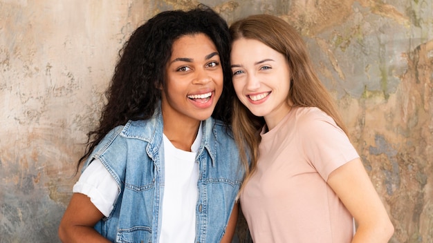 Free photo two female friends smiling and posing together