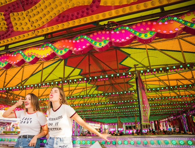 Two female friends standing at amusement park