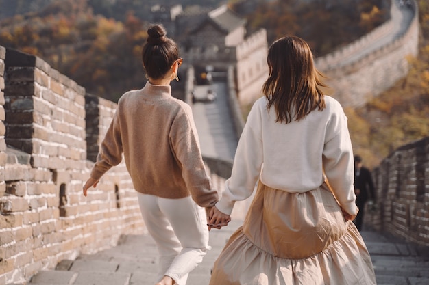 Two female friends walking along the great wall of china near the beijing entarnce