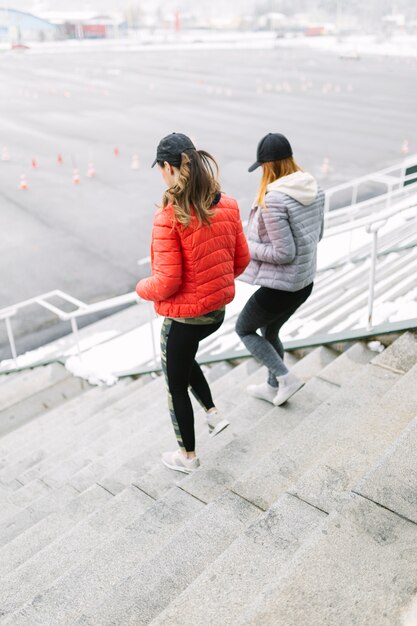 Two female jogger running on staircase in the winter