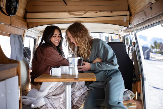 Two female lovers drinking coffee during winter trip