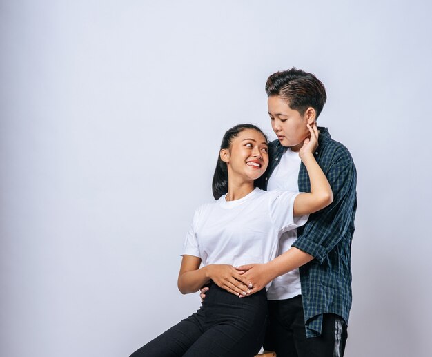 Two female lovers standing and hugging from behind.