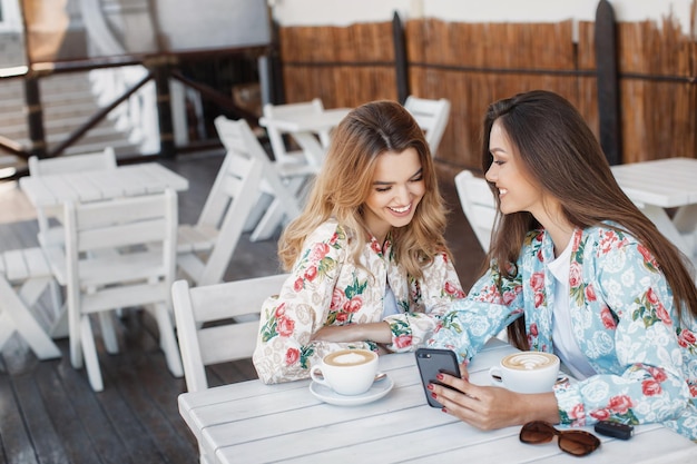 カフェで屋外で笑っている2人の女性