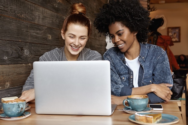 Two female students or lesbians having fun during coffee break at cafe