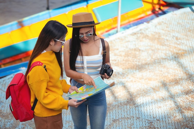 Due turisti femminili tengono una mappa per trovare posti.