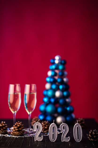 新しい2020年の装飾が施されたシャンパンの2つのフルート。新年のお祝いのコンセプト。