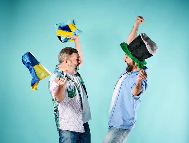 Два футбольных фаната с флагом Украины над синим
