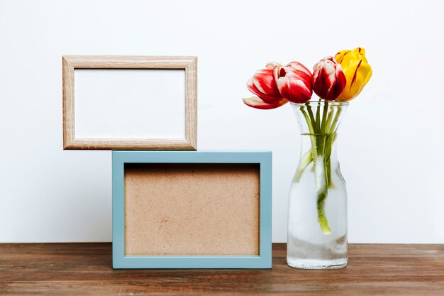 Two frames near tulips in vase