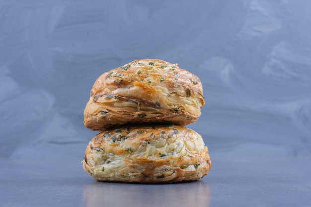 Two fresh delicious pastries on a gray surface