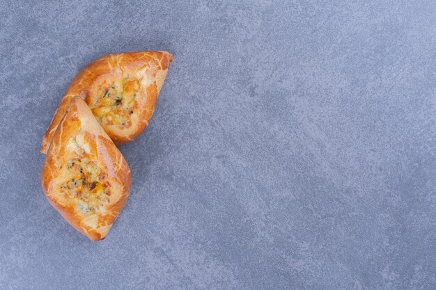 Two fresh delicious pastries on a gray surface