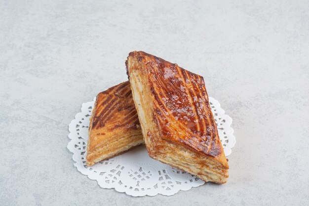 Two fresh delicious pastry on white table.