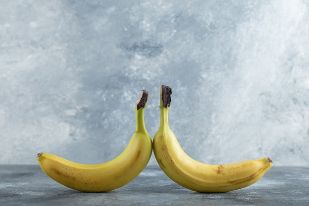 灰色の背景の上に並んで2つの新鮮な有機バナナ。