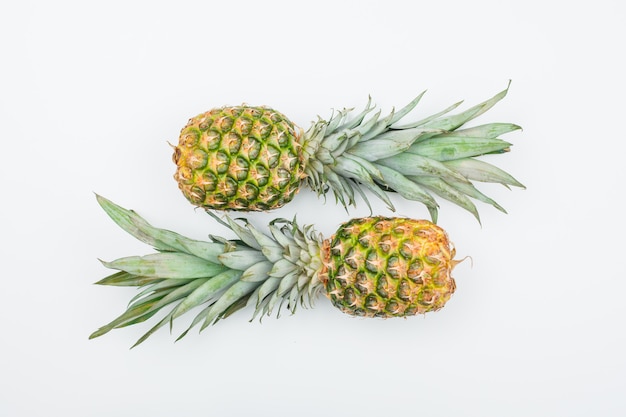 Two fresh pineapples top view on a white