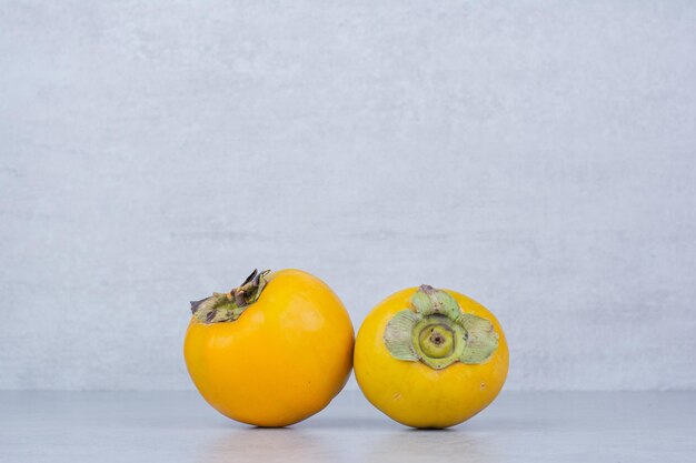 Two fresh sweet persimmons on white background. High quality photo