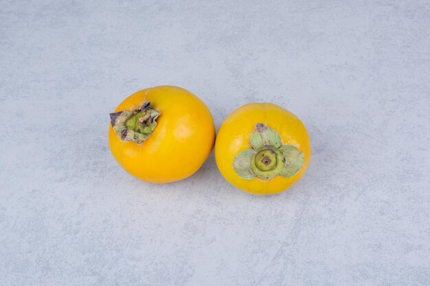 Two fresh sweet persimmons on white background. High quality photo